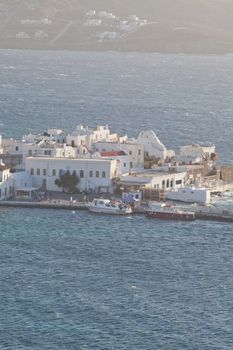 panoramic view of the Mykonos town harbor with famous windmills from the above hills on a sunny summer day, Mykonos, Cyclades, Greece 