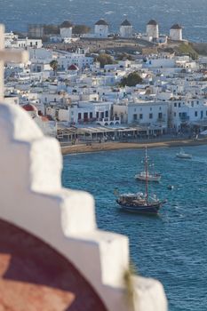 panoramic view of the Mykonos town harbor with famous windmills from the above hills on a sunny summer day, Mykonos, Cyclades, Greece 