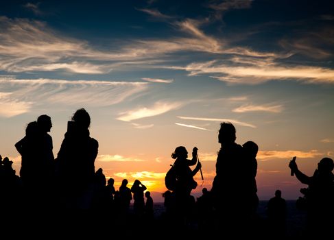 silhouettes of people taking pictures with smartphones