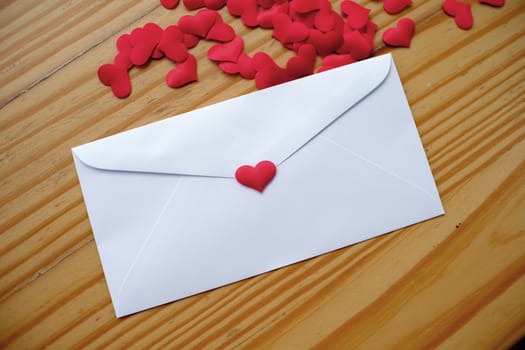 Valentine's day love letter envelope with hearts on wooden background. copy space