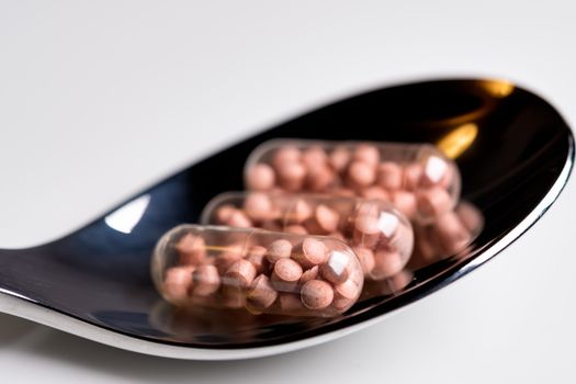 Close up of tablets on a spoon on a table