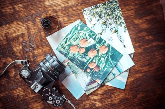 Old photo film roll and retro camera on desk.