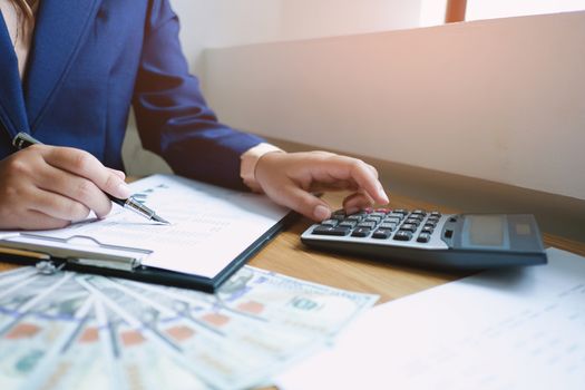 Businessman analyzing investment charts and pressing calculator buttons over documents. Accounting Concept