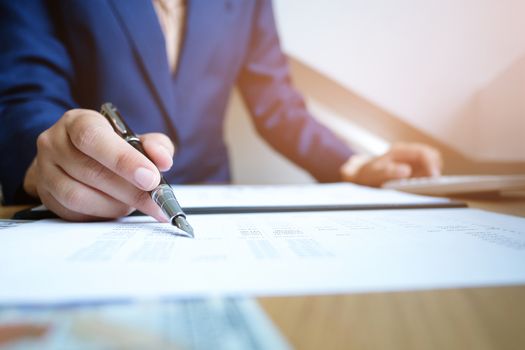 Businessman analyzing investment charts and pressing calculator buttons over documents. Accounting Concept