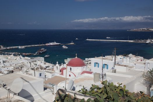 panoramic view of the Mykonos town harbor with famous windmills from the above hills on a sunny summer day, Mykonos, Cyclades, Greece 