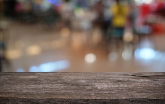 Empty dark wooden table in front of abstract blurred bokeh background of restaurant . can be used for display or montage your products.Mock up for space