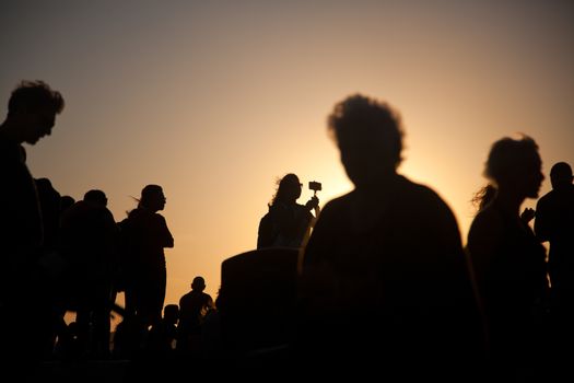 silhouettes of people taking pictures with smartphones