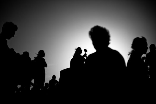 silhouettes of people taking pictures with smartphones