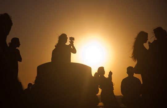 silhouettes of people taking pictures with smartphones