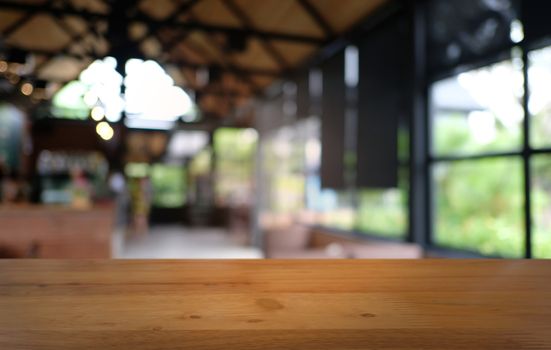 Empty dark wooden table in front of abstract blurred bokeh background of restaurant . can be used for display or montage your products.Mock up for space