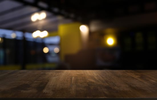 Empty dark wooden table in front of abstract blurred bokeh background of restaurant . can be used for display or montage your products.Mock up for space