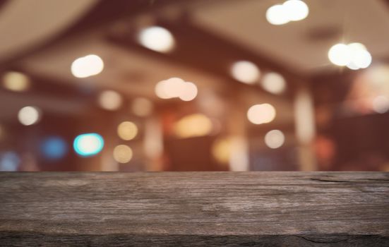 Empty dark wooden table in front of abstract blurred bokeh background of restaurant . can be used for display or montage your products.Mock up for space