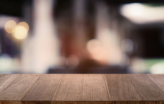 Empty dark wooden table in front of abstract blurred bokeh background of restaurant . can be used for display or montage your products.Mock up for space