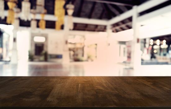 Empty dark wooden table in front of abstract blurred bokeh background of restaurant . can be used for display or montage your products.Mock up for space