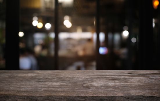 Empty dark wooden table in front of abstract blurred bokeh background of restaurant . can be used for display or montage your products.Mock up for space