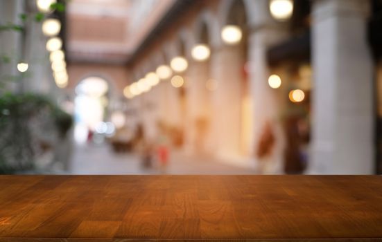 Empty dark wooden table in front of abstract blurred bokeh background of restaurant . can be used for display or montage your products.Mock up for space