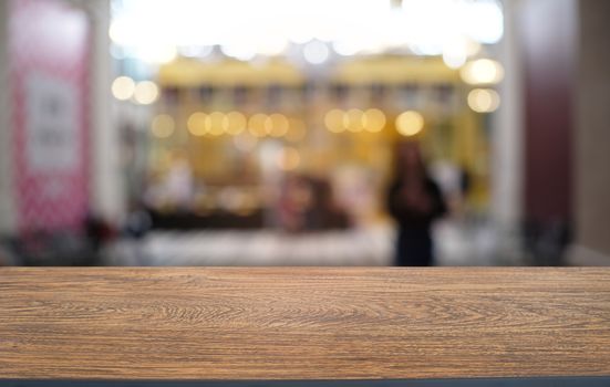 Empty dark wooden table in front of abstract blurred bokeh background of restaurant . can be used for display or montage your products.Mock up for space