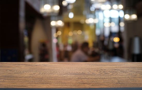 Empty dark wooden table in front of abstract blurred bokeh background of restaurant . can be used for display or montage your products.Mock up for space