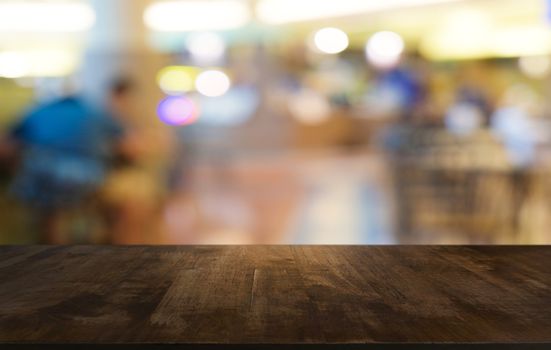 Empty dark wooden table in front of abstract blurred bokeh background of restaurant . can be used for display or montage your products.Mock up for space