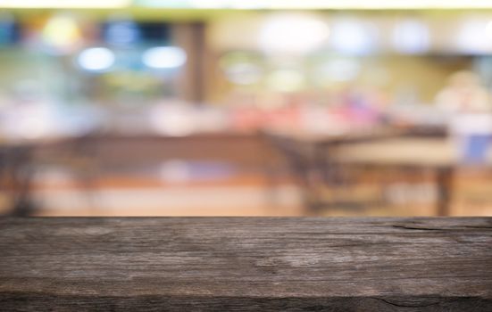 Empty dark wooden table in front of abstract blurred bokeh background of restaurant . can be used for display or montage your products.Mock up for space