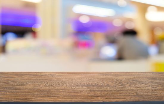 Empty dark wooden table in front of abstract blurred bokeh background of restaurant . can be used for display or montage your products.Mock up for space