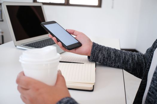 girl using smart phone in office. hand holding smart phone white screen.