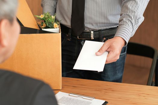 Business man sending resignation letter to boss and Holding Stuff Resign Depress or carrying cardboard box by desk in office