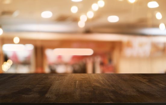 Empty dark wooden table in front of abstract blurred bokeh background of restaurant . can be used for display or montage your products.Mock up for space