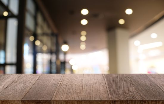 Empty dark wooden table in front of abstract blurred bokeh background of restaurant . can be used for display or montage your products.Mock up for space