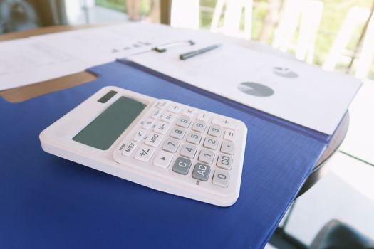 Businesswoman analyzing investment charts and pressing calculator buttons over documents. Accounting Concept