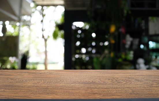 Empty dark wooden table in front of abstract blurred bokeh background of restaurant . can be used for display or montage your products.Mock up for space