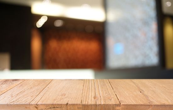 Empty dark wooden table in front of abstract blurred bokeh background of restaurant . can be used for display or montage your products.Mock up for space