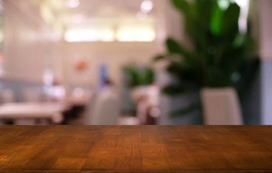 Empty dark wooden table in front of abstract blurred bokeh background of restaurant . can be used for display or montage your products.Mock up for space