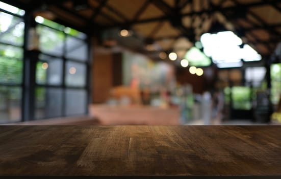 Empty dark wooden table in front of abstract blurred bokeh background of restaurant . can be used for display or montage your products.Mock up for space