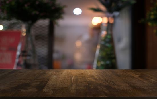 Empty dark wooden table in front of abstract blurred bokeh background of restaurant . can be used for display or montage your products.Mock up for space