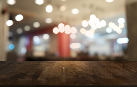 Empty dark wooden table in front of abstract blurred bokeh background of restaurant . can be used for display or montage your products.Mock up for space