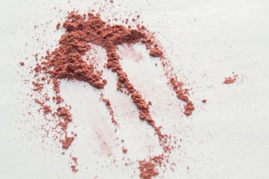 Scattered beige powder, Crumbles natural makeup powder on white background.