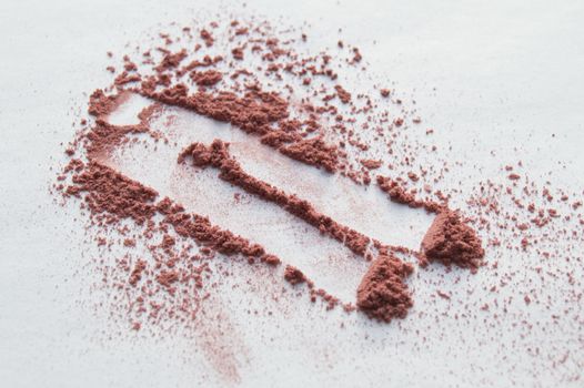 Scattered beige powder, Crumbles natural makeup powder on white background.