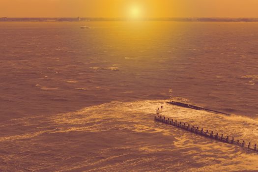 the port of vlissingen at sunset, wooden poles with watchtower and tiny lighthouse, wild sea landscape with waves, zeeland, The netherlands