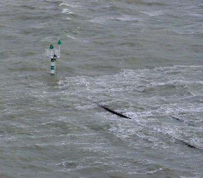 high water level at sea, over flooded wooden poles and watching tower