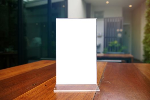 Mock up Menu frame standing on wood table in Bar restaurant cafe. space for text