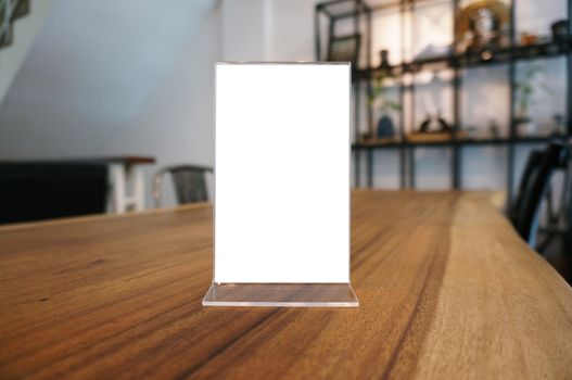 Mock up Menu frame standing on wood table in Bar restaurant cafe. space for text.