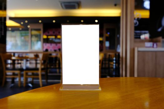 Mock up Menu frame standing on wood table in Bar restaurant cafe. space for text