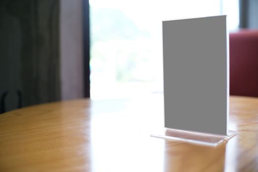 Mock up Menu frame standing on wood table in Bar restaurant cafe. space for text