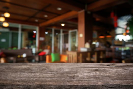 Empty dark wooden table in front of abstract blurred background of cafe and coffee shop interior. can be used for display or montage your products