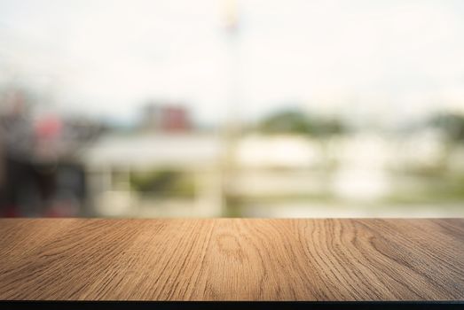 Empty dark wooden table in front of abstract blurred background of cafe and coffee shop interior. can be used for display or montage your products