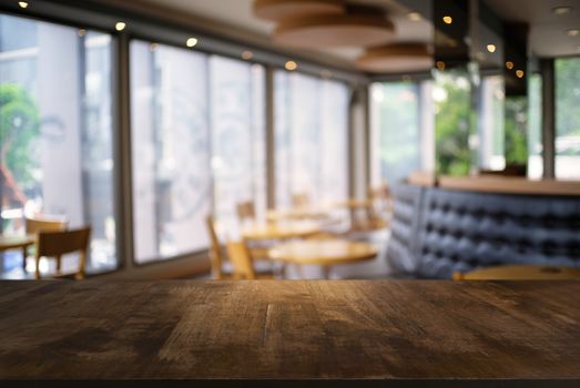 Empty dark wooden table in front of abstract blurred background of coffee shop . can be used for display or montage your products.Mock up for display of product.