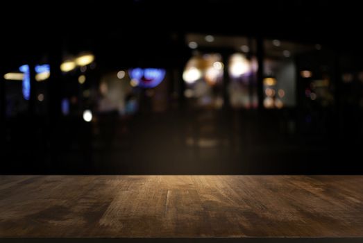 Empty of dark wooden table in front of abstract blurred background of bokeh light . can be used for display or montage your products.Mock up for display of product.