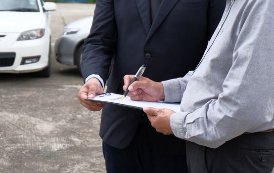 Loss Adjuster Insurance Agent Inspecting Damaged Car 