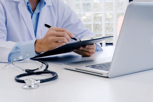 close up of patient and doctor taking notes or Professional medical doctor in white uniform gown coat interview